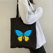 Woman holding Ukrainian patriotic grocery tote bag with butterfly design