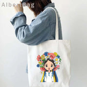 Woman carrying Ukrainian patriotic grocery tote bag with colorful design