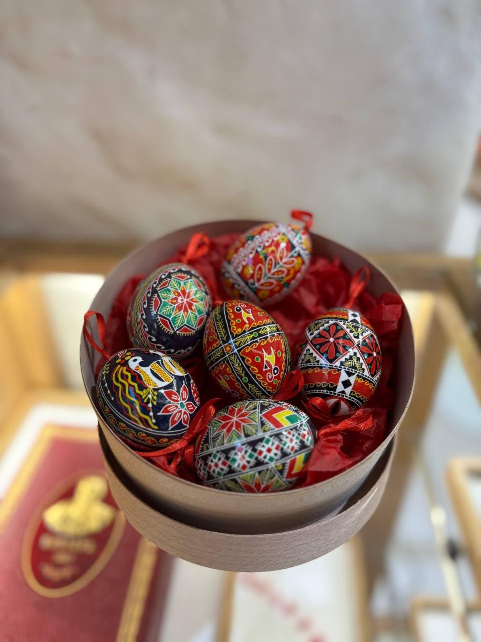 Set of 6 hand-painted Ukrainian Pysanky Easter eggs in a decorative box, showcasing traditional folk symbols on blown chicken shells.