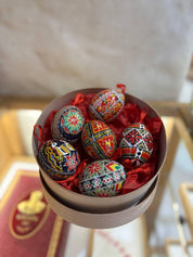 Set of 6 hand-painted Ukrainian Pysanky Easter eggs in a decorative box, showcasing traditional folk symbols on blown chicken shells.