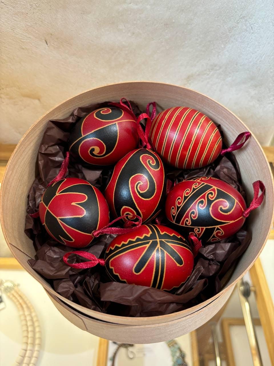 Set of 6 handmade Ukrainian Pysanky eggs with traditional red and black folk designs, displayed in a decorative box.