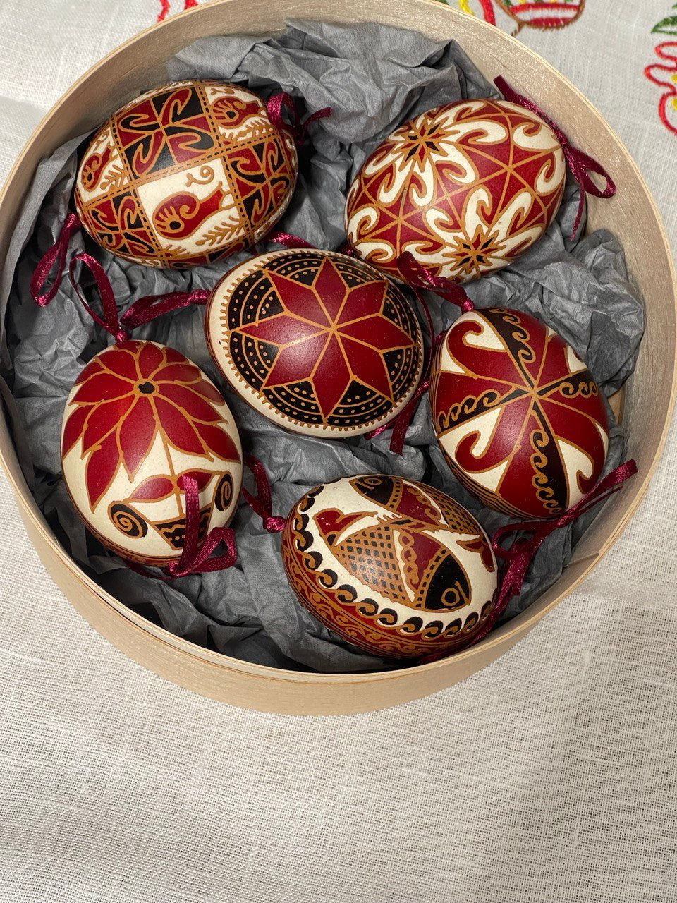 Set of 6 handmade Ukrainian Pysanky eggs with traditional red and gold designs in decorative box for Easter or Christmas gift.
