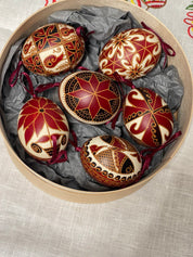 Set of 6 handmade Ukrainian Pysanky eggs with traditional red and gold designs in decorative box for Easter or Christmas gift.
