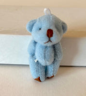 Tiny soft fuzzy blue hand-sewn teddy bear with moveable arms and legs, featuring a loop for hanging as a cute decoration.