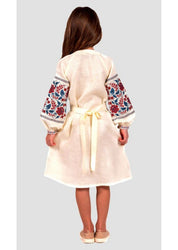 Girl wearing a traditional Ukrainian embroidered linen dress with colorful floral cross-stitch on sleeves and a waist tie, seen from the back.