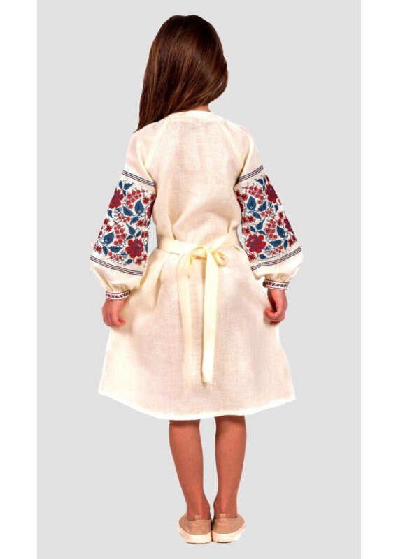 Girl wearing a traditional Ukrainian embroidered linen dress with colorful floral cross-stitch on sleeves and a waist tie, seen from the back.