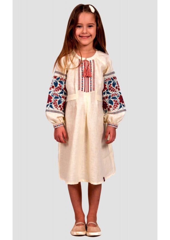 Girl wearing traditional Ukrainian embroidered linen vyshyvanka dress with floral cross-stitch sleeves and buttoned straps.