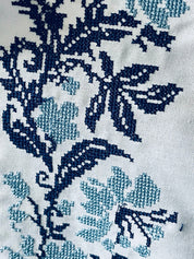 Close-up of Ukrainian vyshyvanka shirt embroidery with blue floral patterns on fabric.