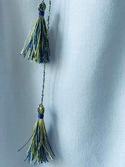 Close-up of blue and yellow tassels on Ukrainian Vyshyvanka dress for girls.