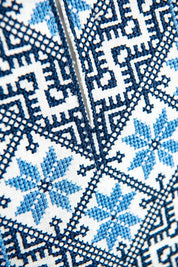 Close-up of traditional Ukrainian blue embroidery on white linen fabric