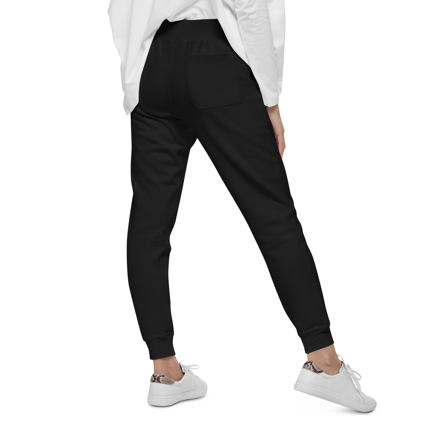 Woman wearing black Ukrainian Flag fleece sweatpants with white sneakers, showcasing back pocket design in a casual style.