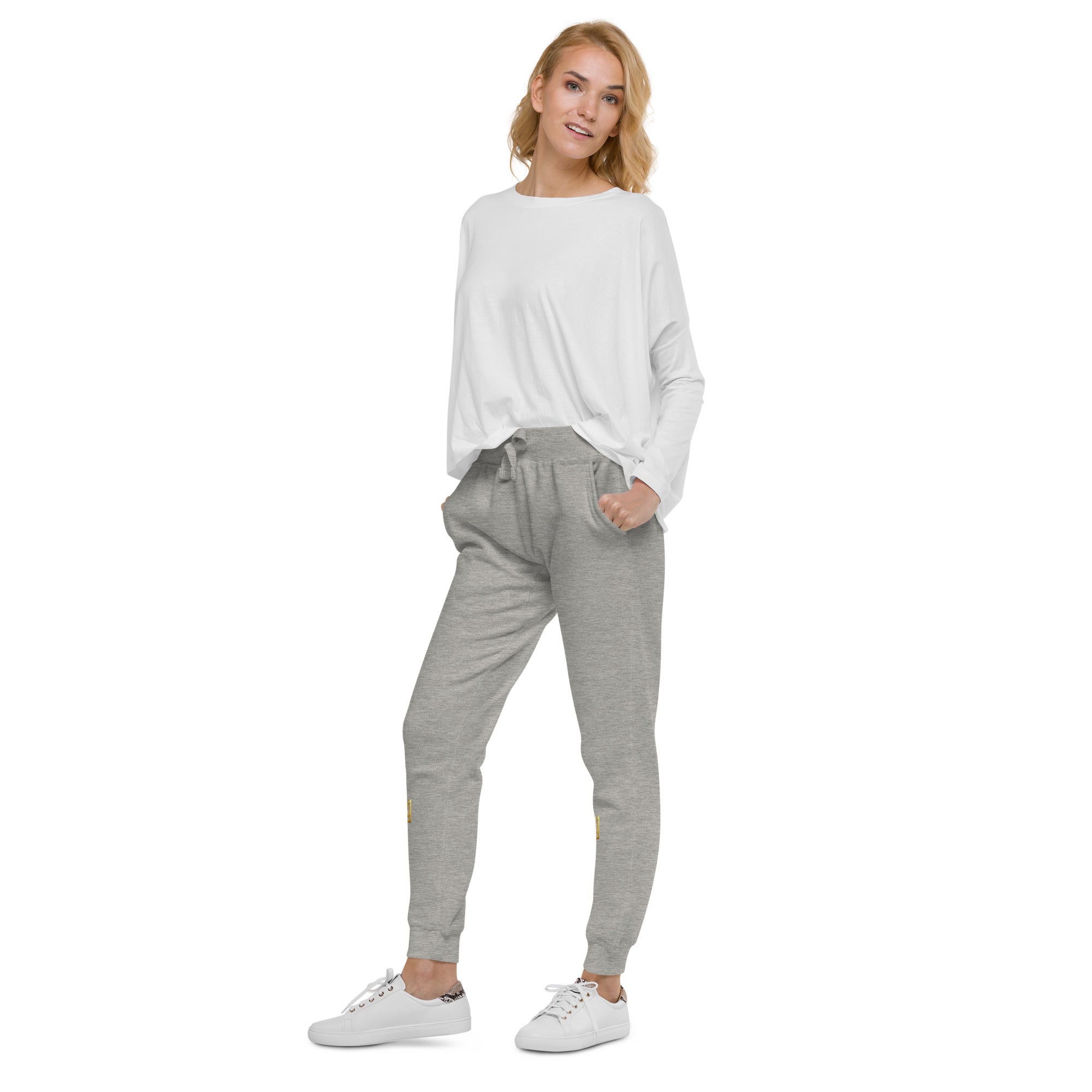 Woman wearing Ukrainian Vibe Trizub Collection unisex fleece sweatpants with white top and sneakers, showcasing casual style.
