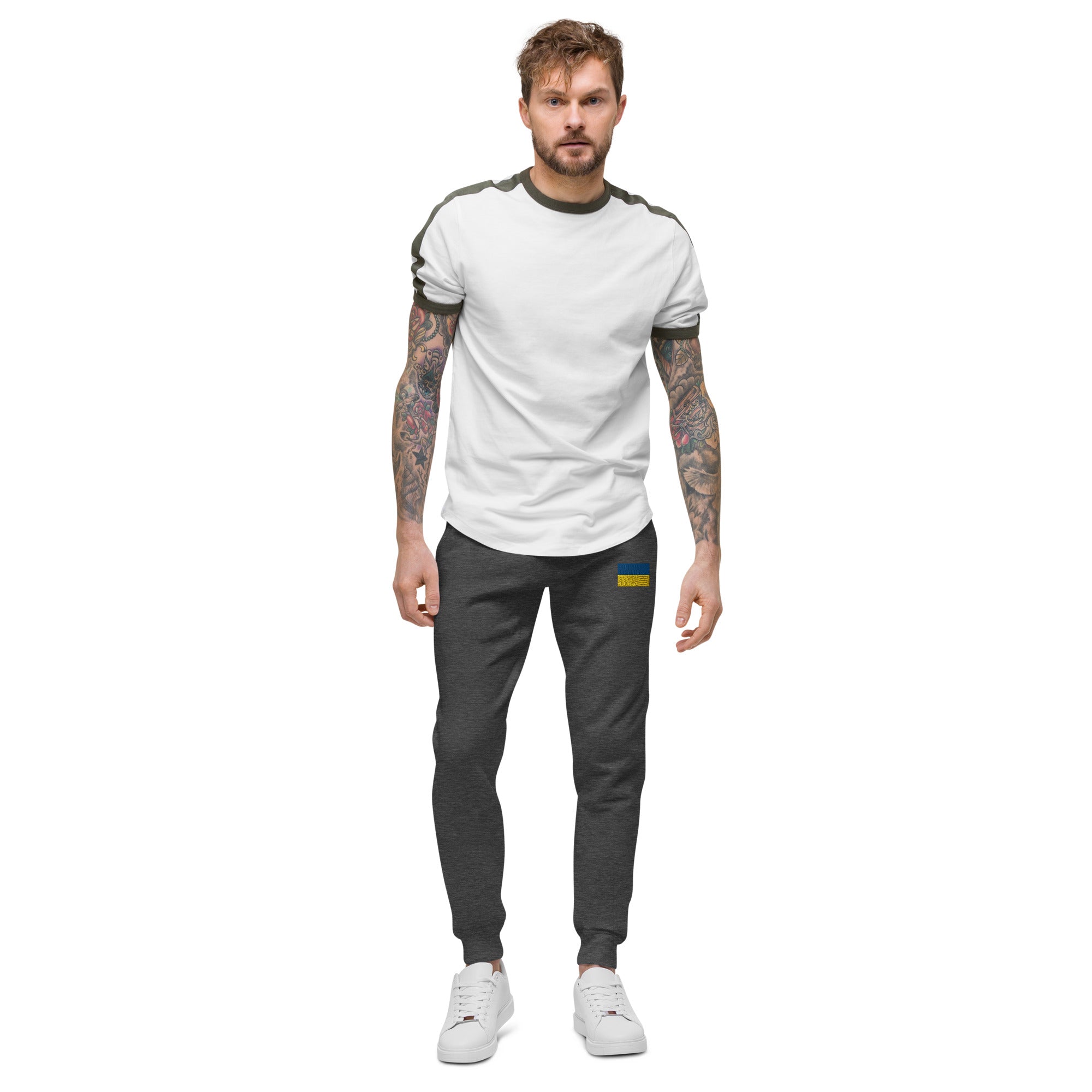 Man wearing Ukrainian Flag fleece sweatpants from the Ukrainian Vibe Trizub Collection, styled with a white t-shirt and sneakers.