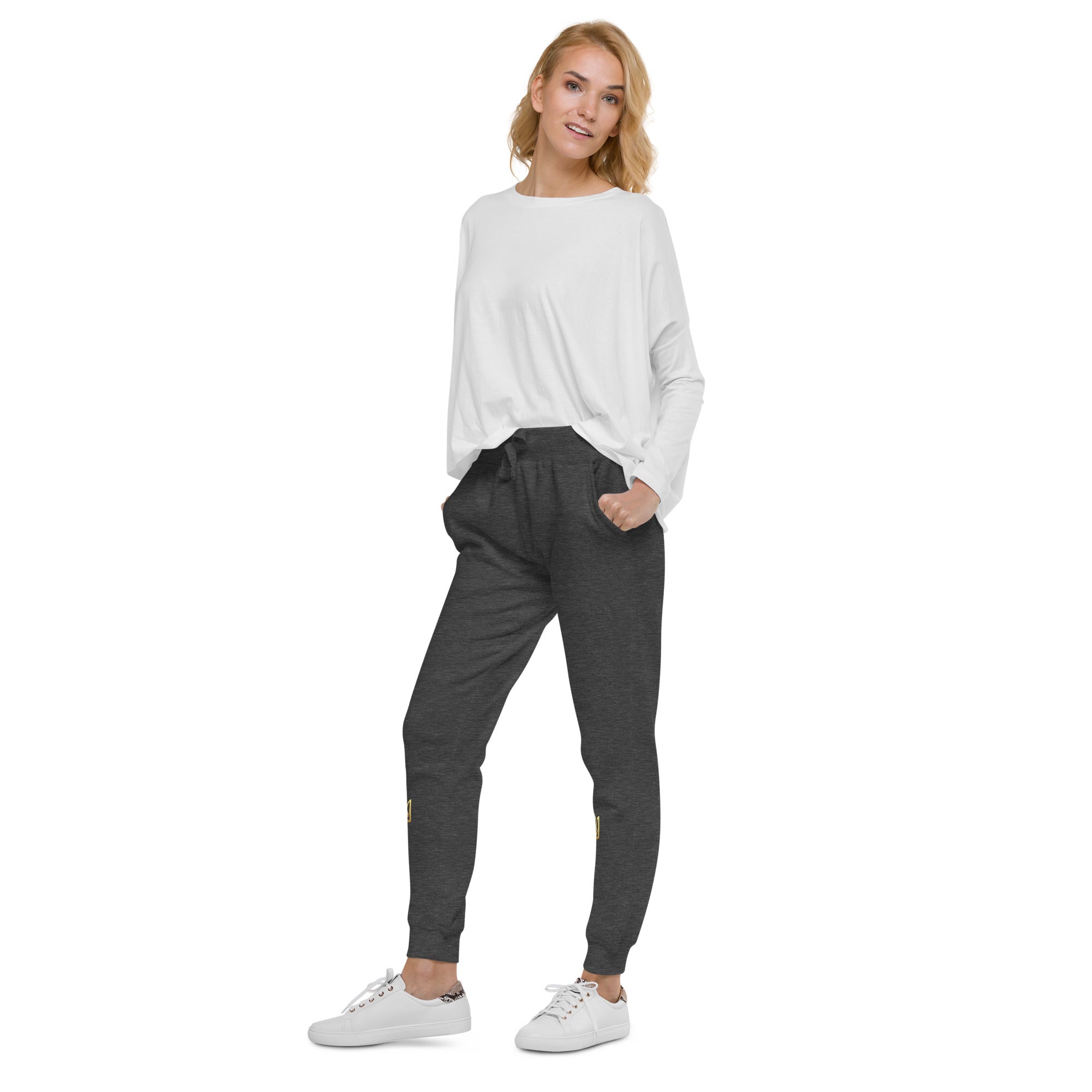 Model wearing Ukrainian Vibe Trizub unisex fleece sweatpants in Charcoal Heather with white sneakers and a casual top.