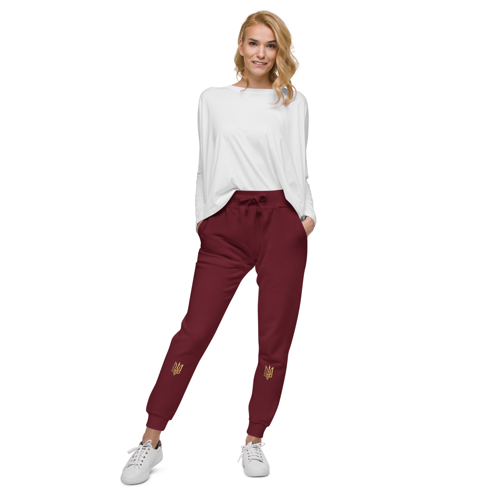Model wearing Ukrainian Vibe Trizub Collection unisex fleece sweatpants in maroon, paired with a white top and sneakers.