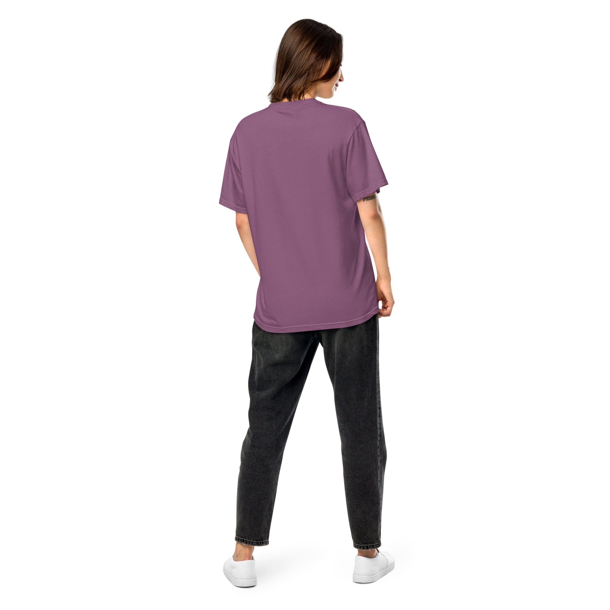 Back view of a woman wearing a purple Ukrainian Vibe Trizub Collection garment-dyed heavyweight t-shirt with black jeans and white sneakers.
