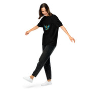 Woman in black Ukrainian Vibe Trizub Collection t-shirt with blue emblem, showing off relaxed fit and style, paired with dark jeans and white sneakers.