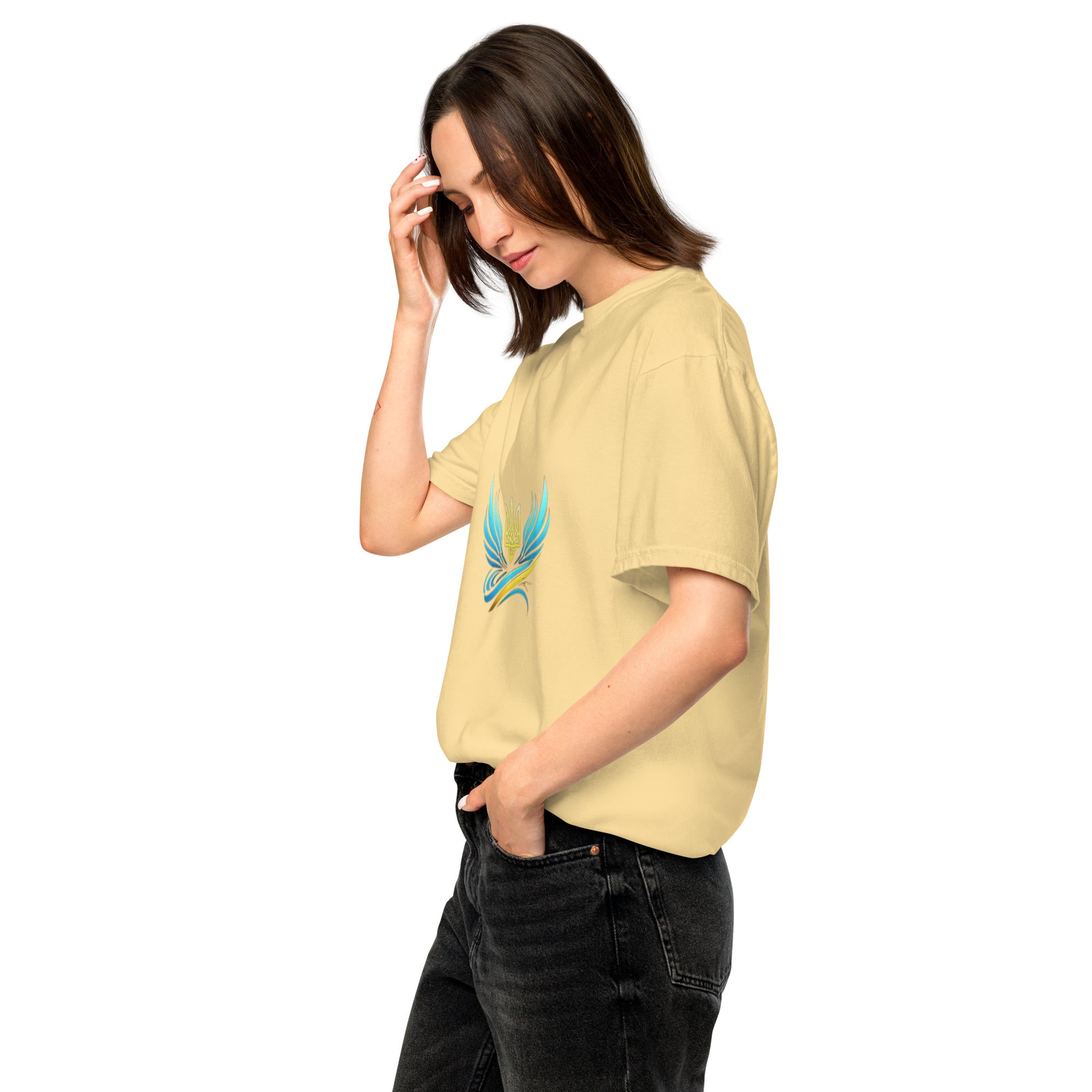 Woman wearing Ukrainian Vibe Trizub Collection garment-dyed heavyweight t-shirt in beige with embroidered emblem, casual style.