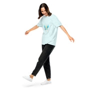 Woman wearing Ukrainian Vibe Trizub Collection tee, garment-dyed heavyweight, pastel blue with Trizub symbol, black jeans, white sneakers.