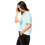 Woman wearing Ukrainian Vibe Trizub Collection tee with blue and yellow trident design, side view, white background.