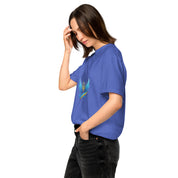 Woman wearing Ukrainian Vibe Trizub Collection garment-dyed heavyweight t-shirt in blue with Trizub logo, side view.