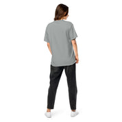 Back view of woman wearing Ukrainian Vibe Trizub Collection heavy grey t-shirt, relaxed fit, paired with black jeans, casual fashion.
