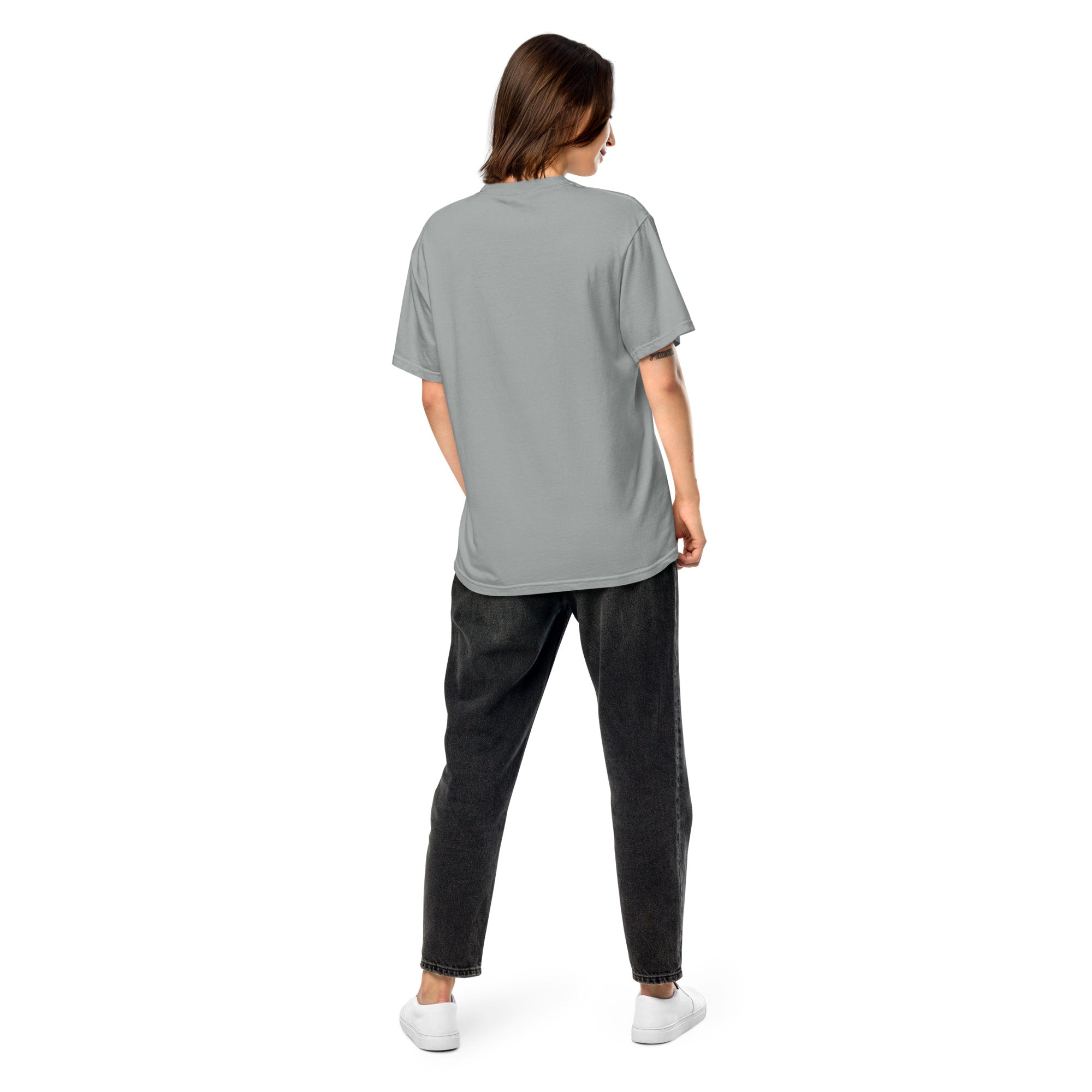 Back view of woman wearing Ukrainian Vibe Trizub Collection heavy grey t-shirt, relaxed fit, paired with black jeans, casual fashion.