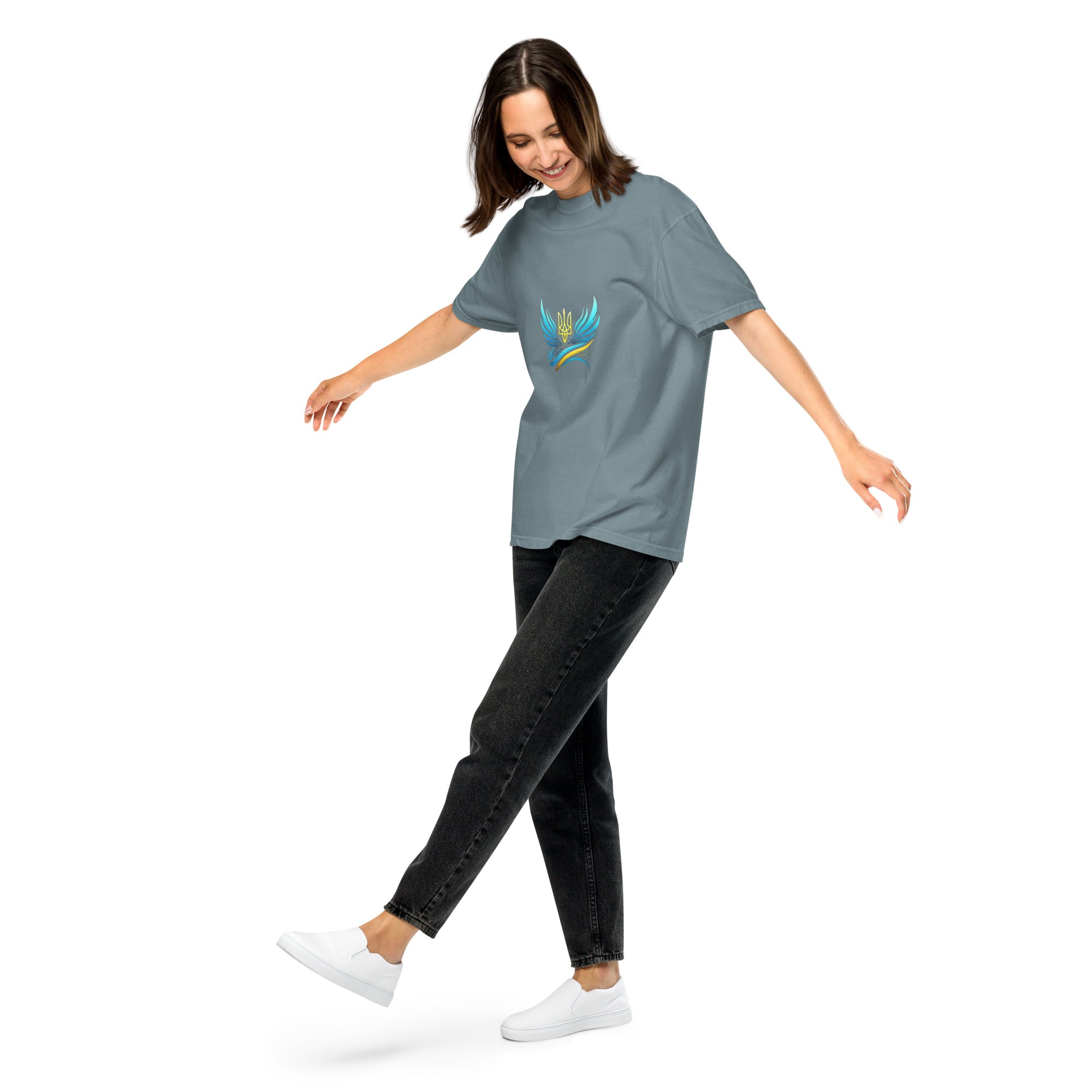 Woman wearing Ukrainian Vibe Trizub Collection heavyweight t-shirt in gray, showcasing vibrant trident design, paired with black jeans.