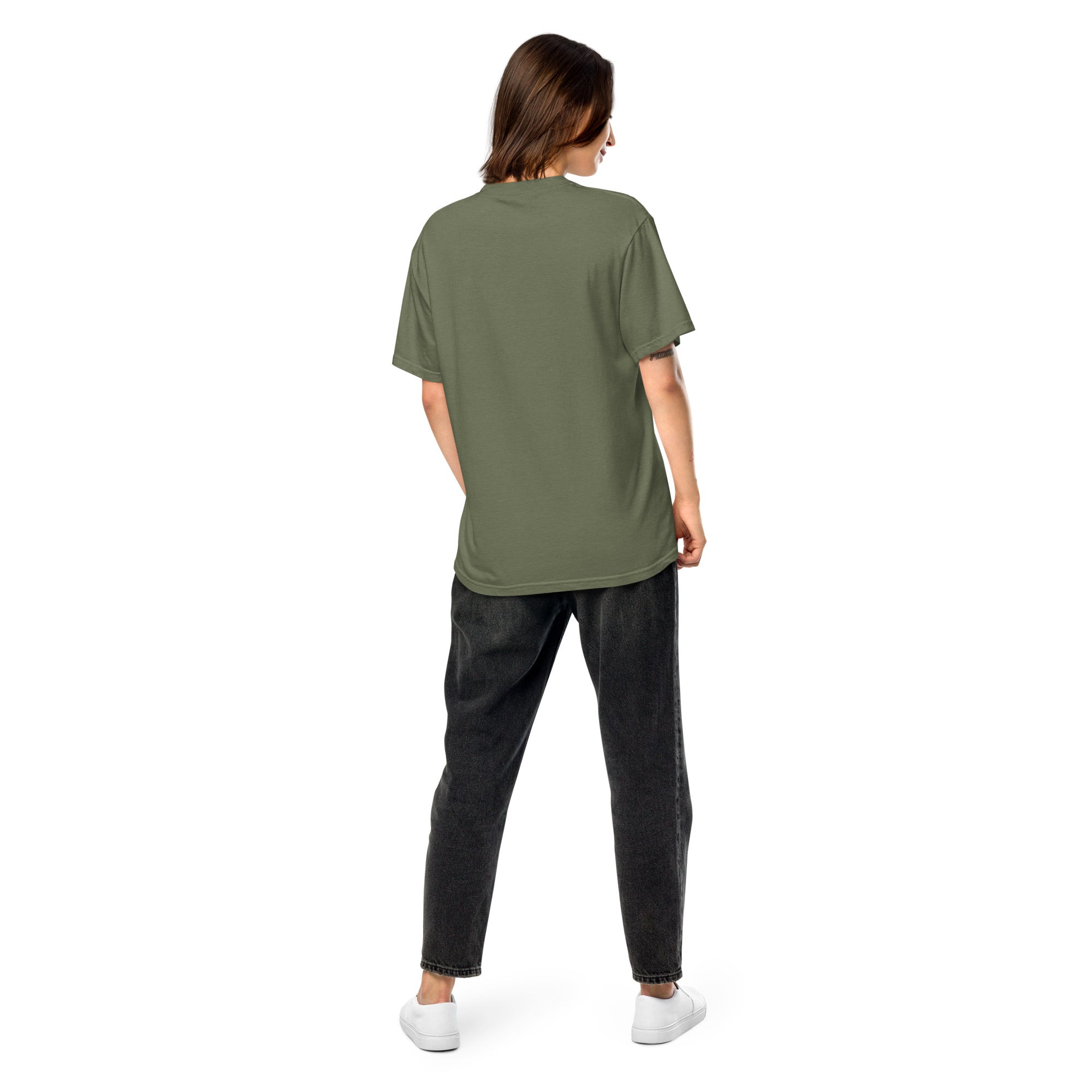 Back view of woman wearing Ukrainian Vibe Trizub Collection heavyweight t-shirt in green, paired with dark jeans and white sneakers.