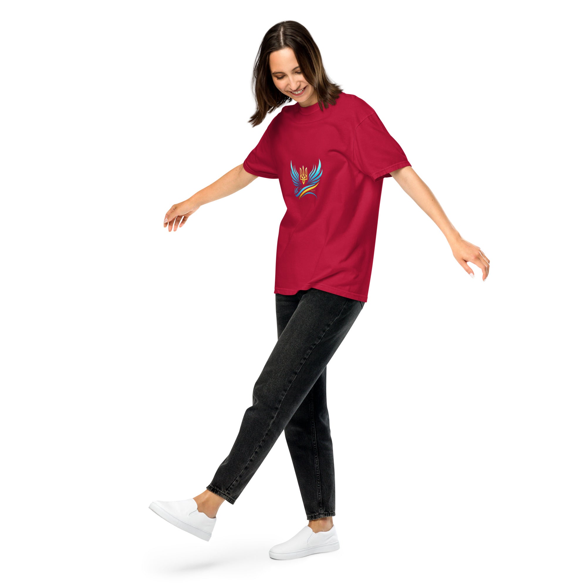 Woman wearing Ukrainian Vibe Trizub Collection red heavyweight t-shirt with trident design, paired with black jeans and white sneakers.