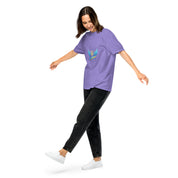 Woman wearing a purple Ukrainian Vibe Trizub Collection heavyweight t-shirt with a Trident emblem, paired with black jeans and white sneakers.