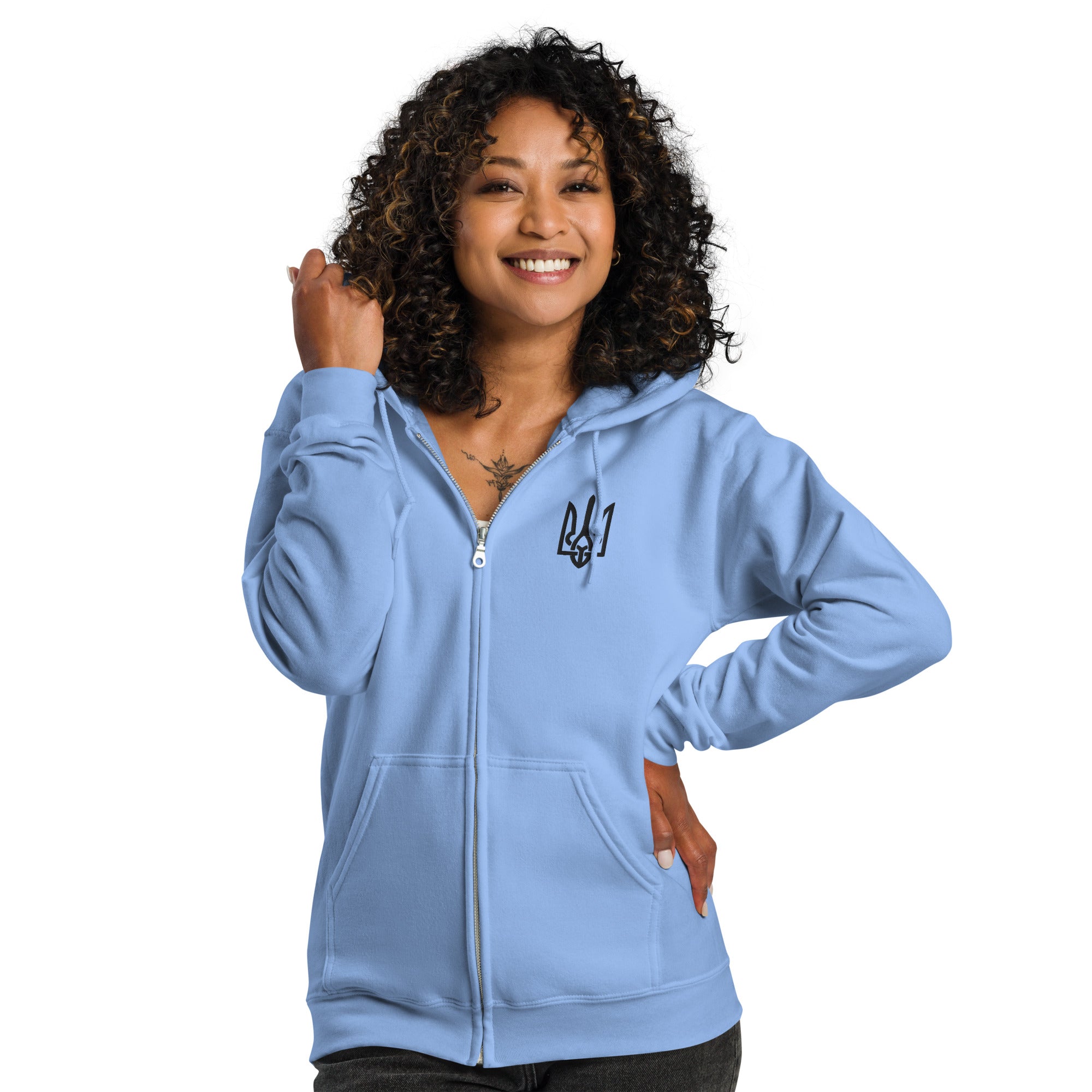 Woman wearing a light blue zip hoodie with Ukrainian Tryzub design, showcasing casual cozy style.