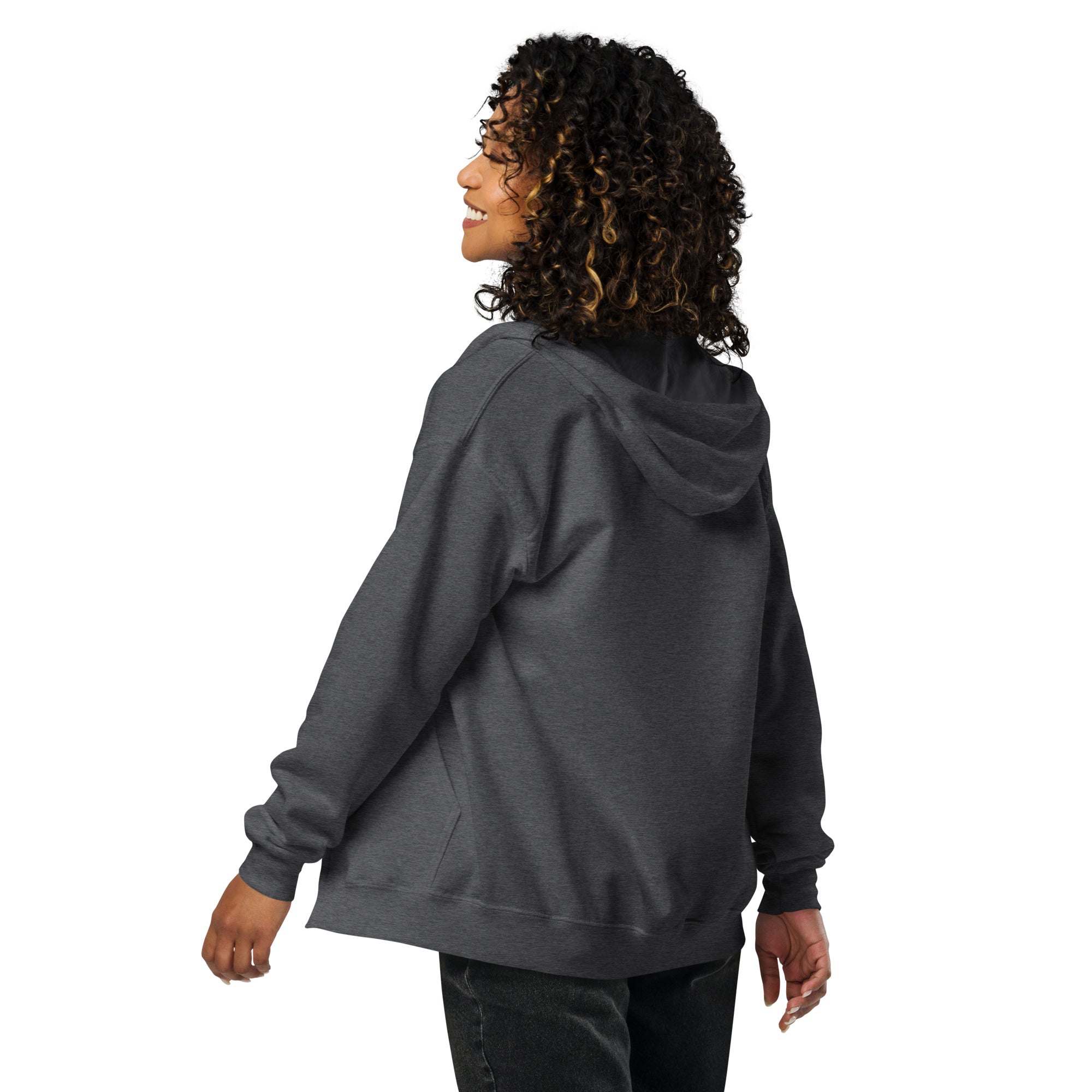 Woman wearing a gray heavy blend zip hoodie with Ukrainian Tryzub design, showcasing cozy fleece and a tailored fit.