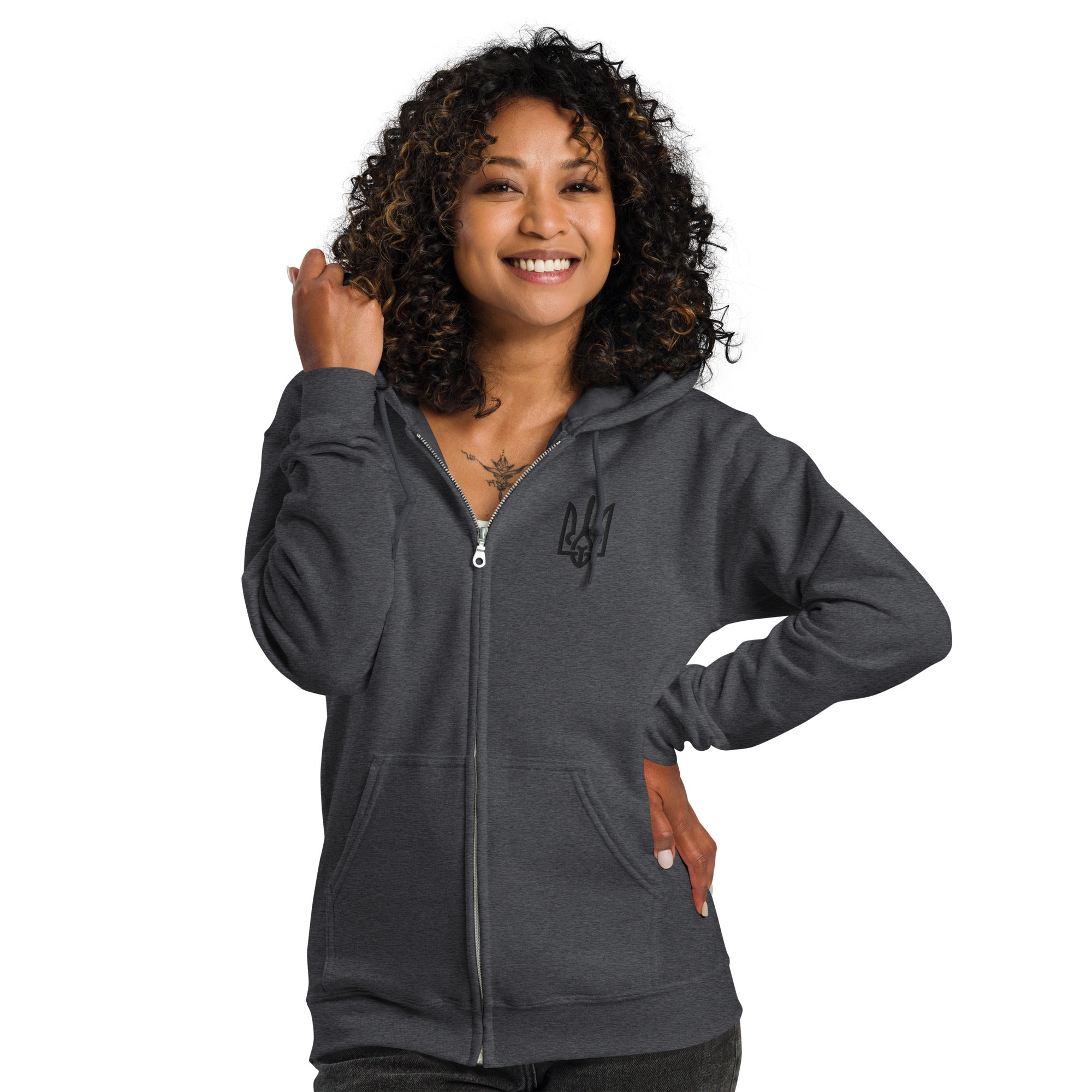 Woman wearing a dark gray zip hoodie with Ukrainian Tryzub design, smiling confidently. Perfect for warmth and style in cooler weather.