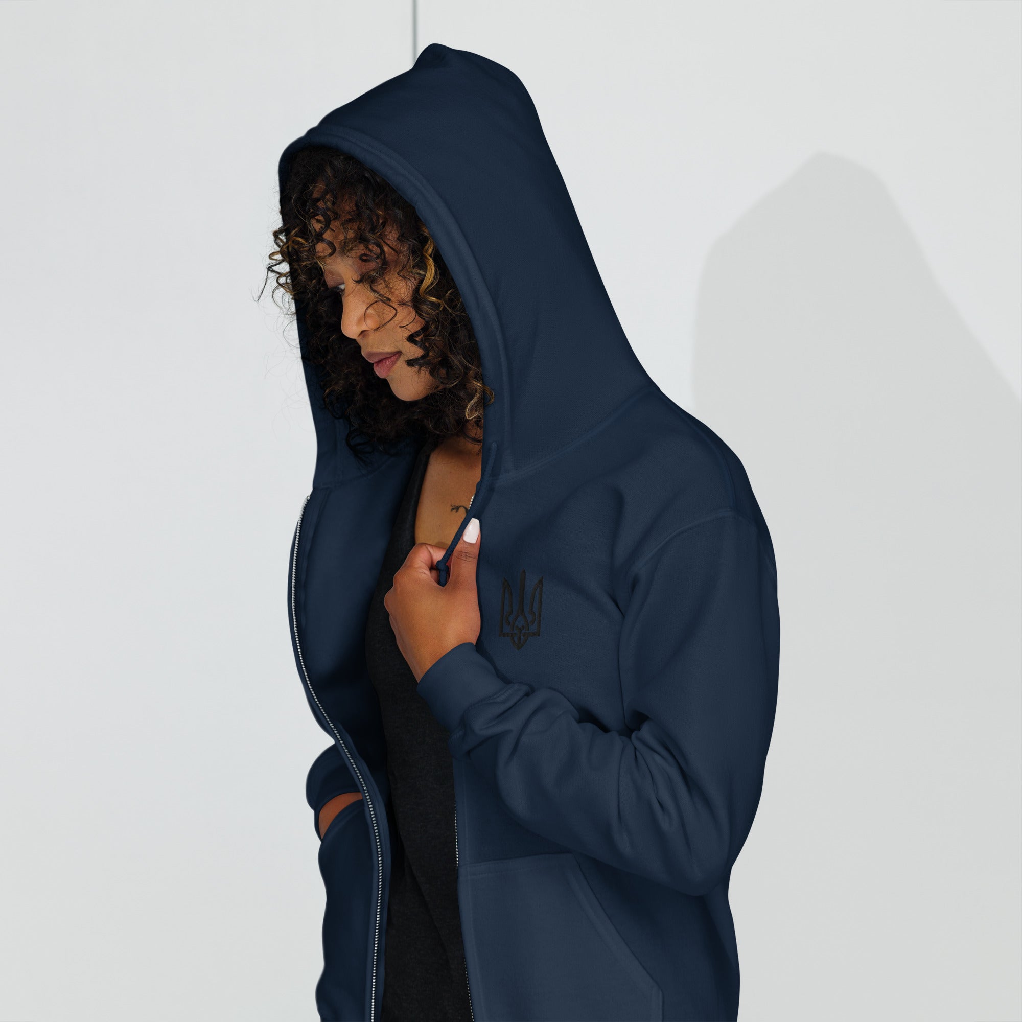 Woman wearing navy zip hoodie with Ukrainian Tryzub design, featuring a cozy fleece lining and tailored fit for warmth and comfort.