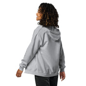Woman wearing a cozy gray zip hoodie with Ukrainian Tryzub design, featuring soft fleece lining and tailored fit, shown from the back.