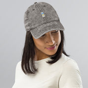 Woman wearing a vintage washed-out cotton twill cap with embroidered Ukrainian Tryzub design.