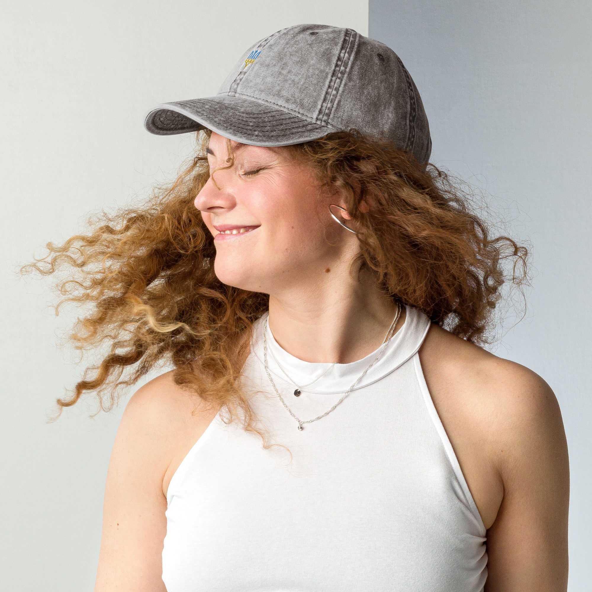 Woman wearing vintage unisex cotton twill cap with embroidered Ukrainian Tryzub, showcasing trendy and relaxed style.