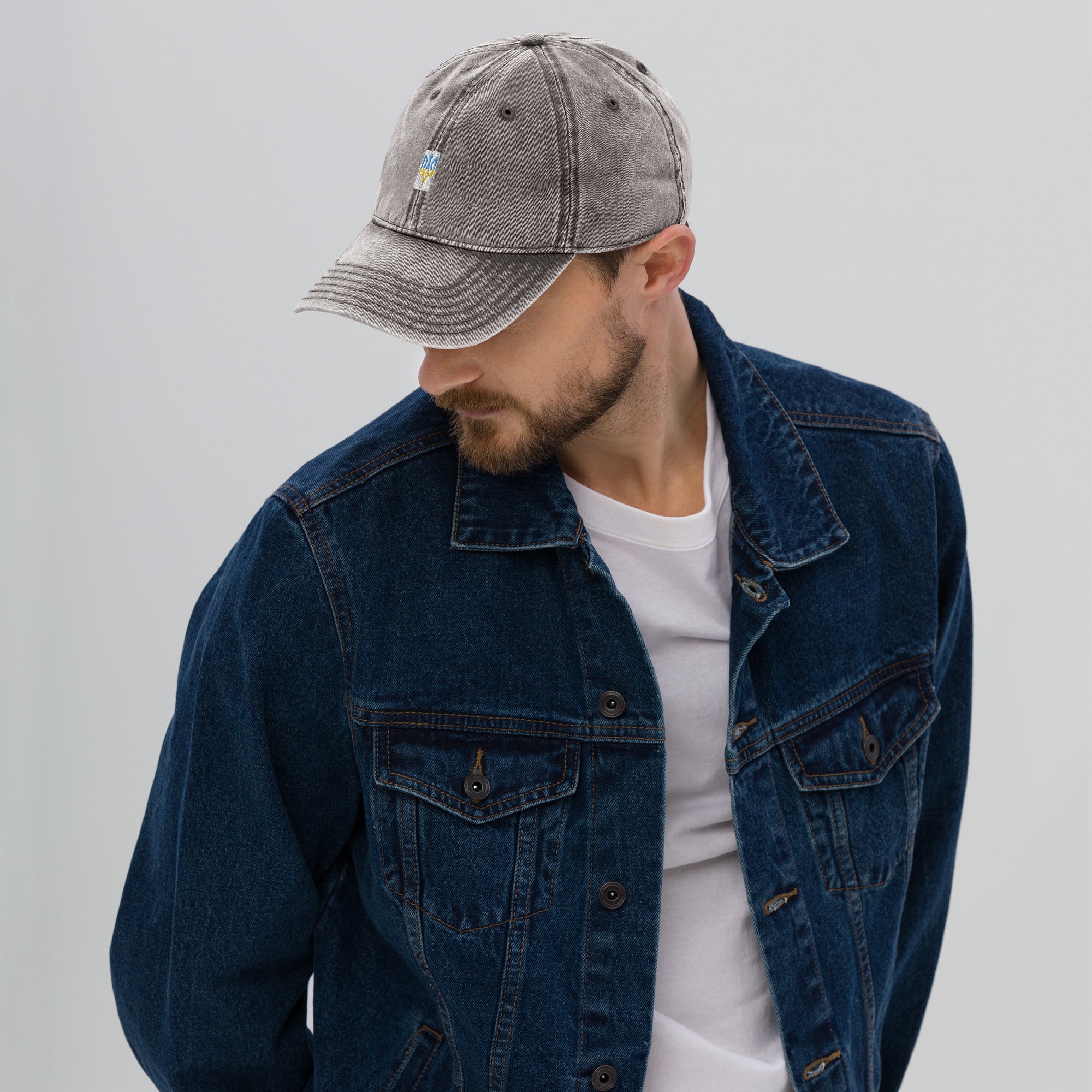 Man wearing vintage cotton twill cap with embroidered Ukrainian Tryzub, denim jacket, and white t-shirt, showcasing relaxed style.