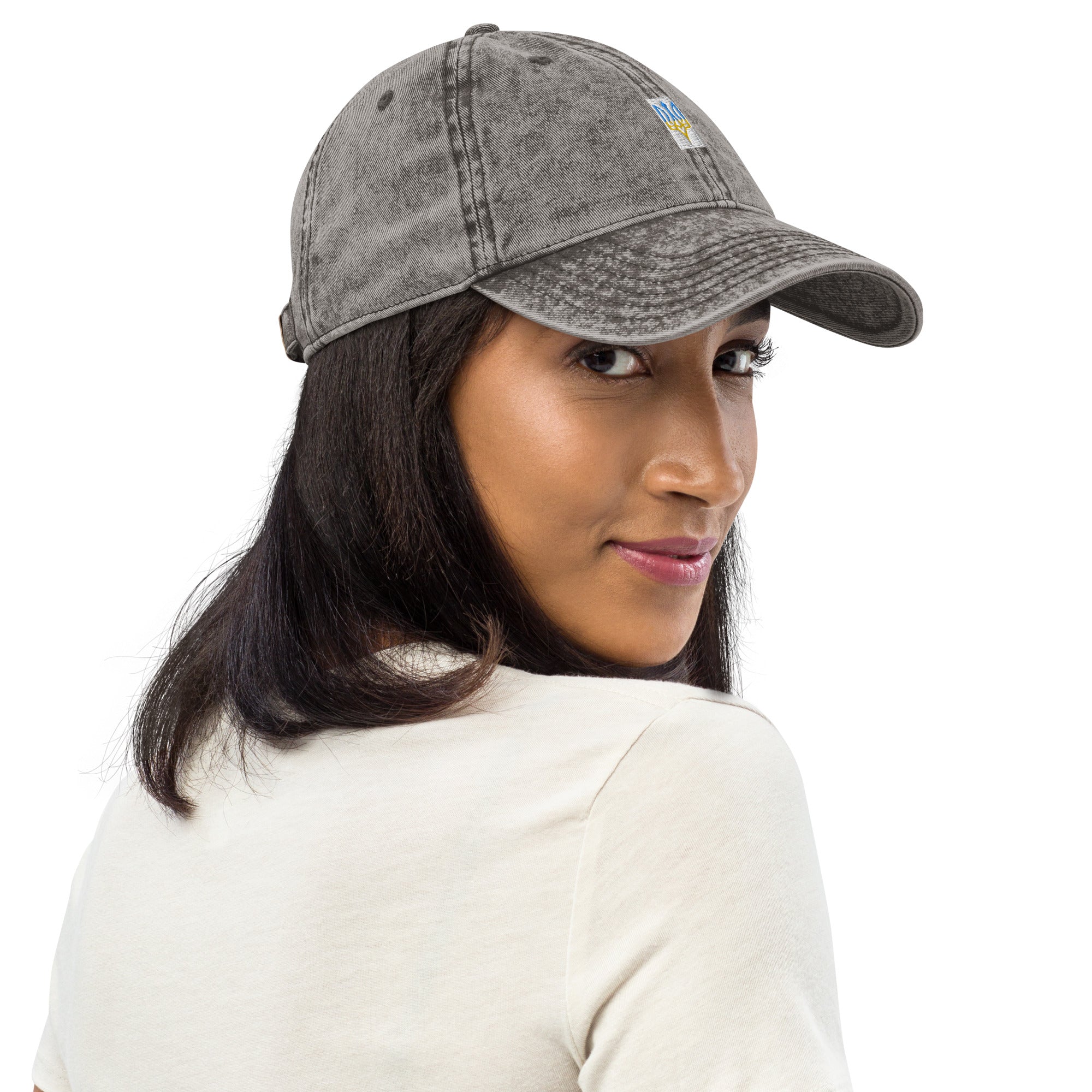 Woman wears vintage unisex cotton twill cap with embroidered Ukrainian Tryzub, showcasing trendy washed-out effect and relaxed fit.