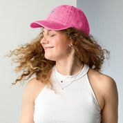 Woman wearing a vintage pink cotton twill cap with embroidered Tryzub design, showcasing a relaxed fit and stylish look.