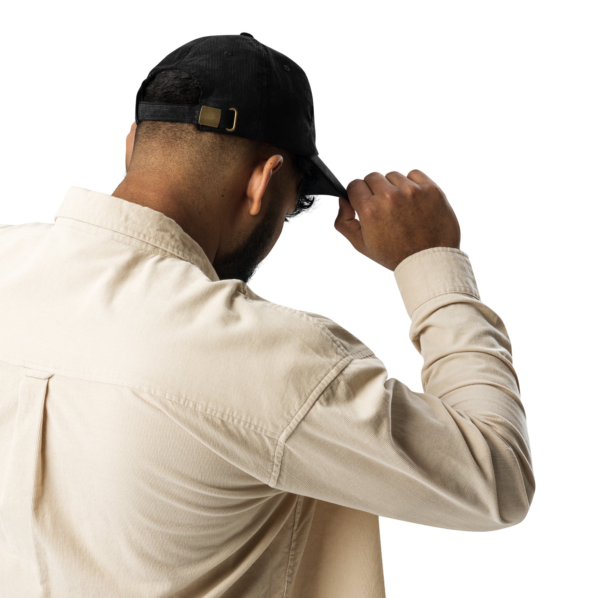 Person wearing a black corduroy cap with Ukrainian Tryzub, showcasing its adjustable feature from the back, paired with a beige shirt.