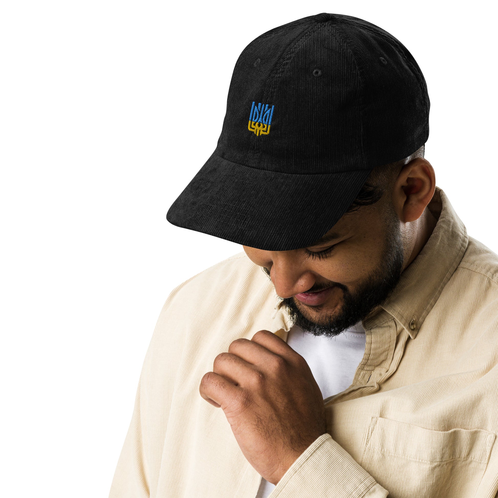 Man wearing black vintage corduroy cap with Ukrainian Tryzub emblem, showcasing retro style and patriotic flair.