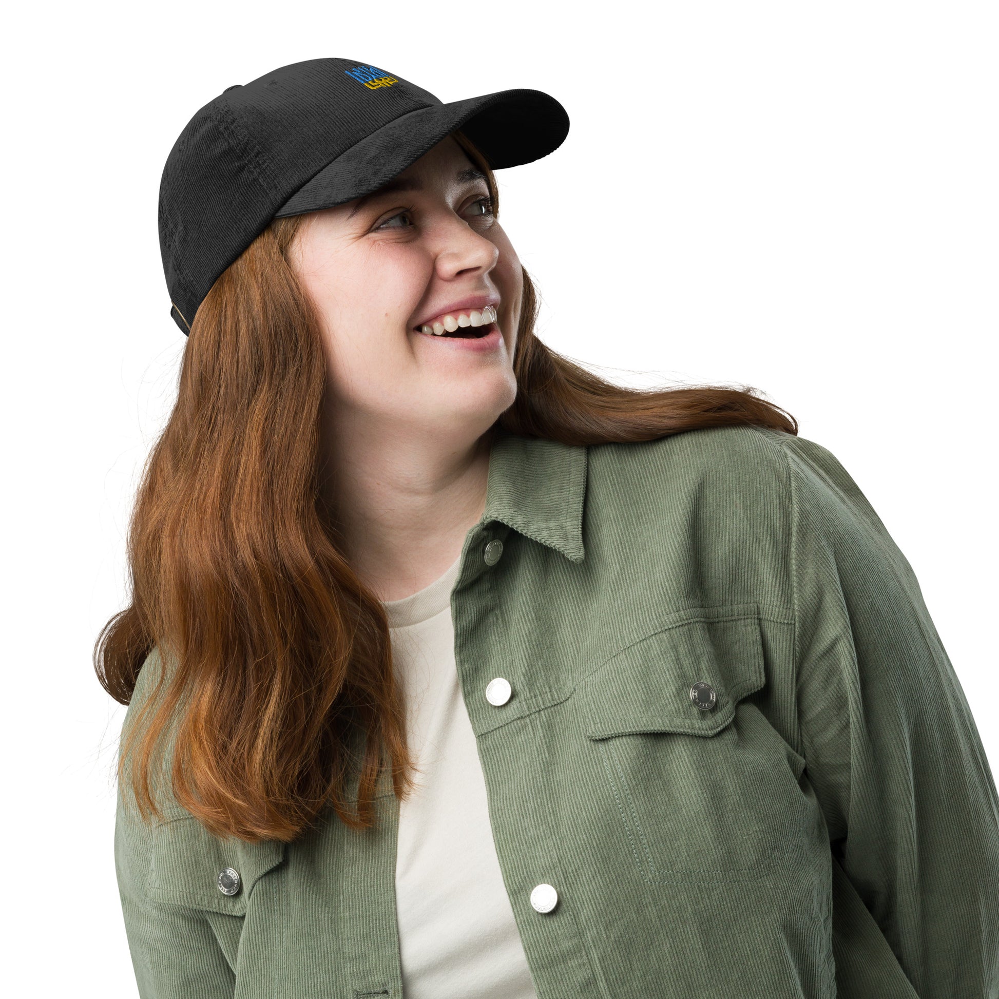Woman wearing vintage black corduroy cap with Ukrainian Tryzub emblem, styled with green jacket and white shirt.
