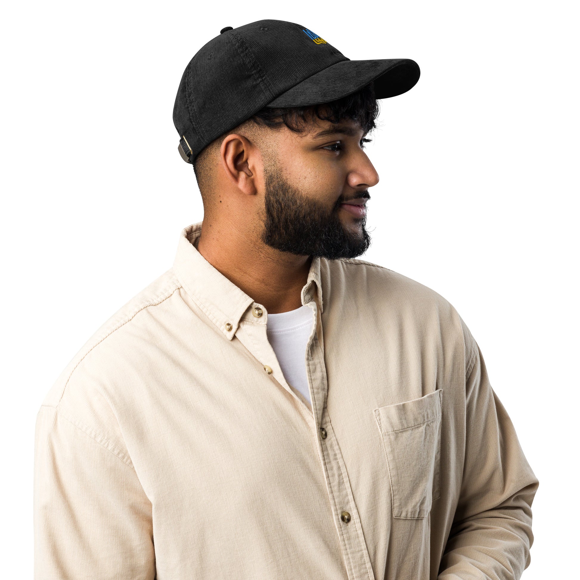 Man wearing a vintage corduroy cap with Ukrainian Tryzub emblem, showcasing retro style and modern patriotic flair.