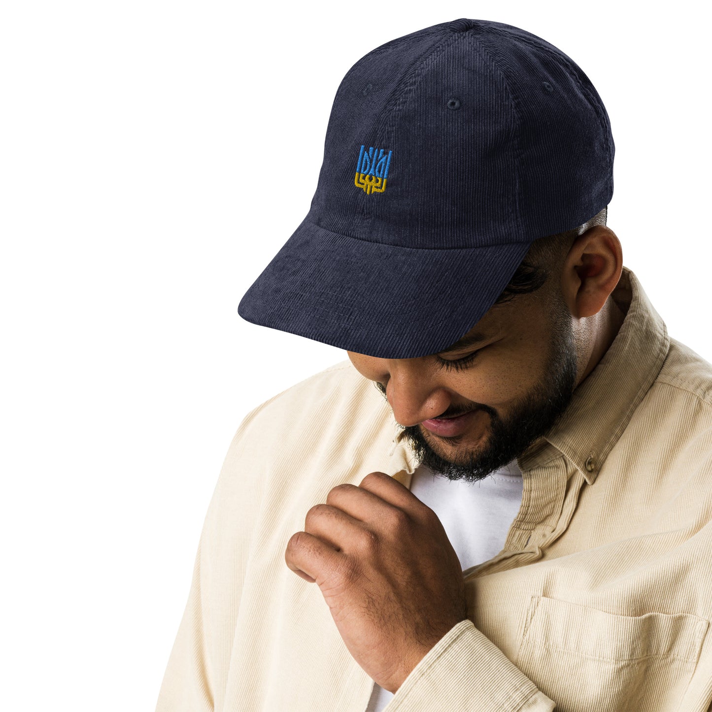 Vintage corduroy cap with Ukrainian Tryzub emblem worn by man, showcasing retro style and patriotic flair.