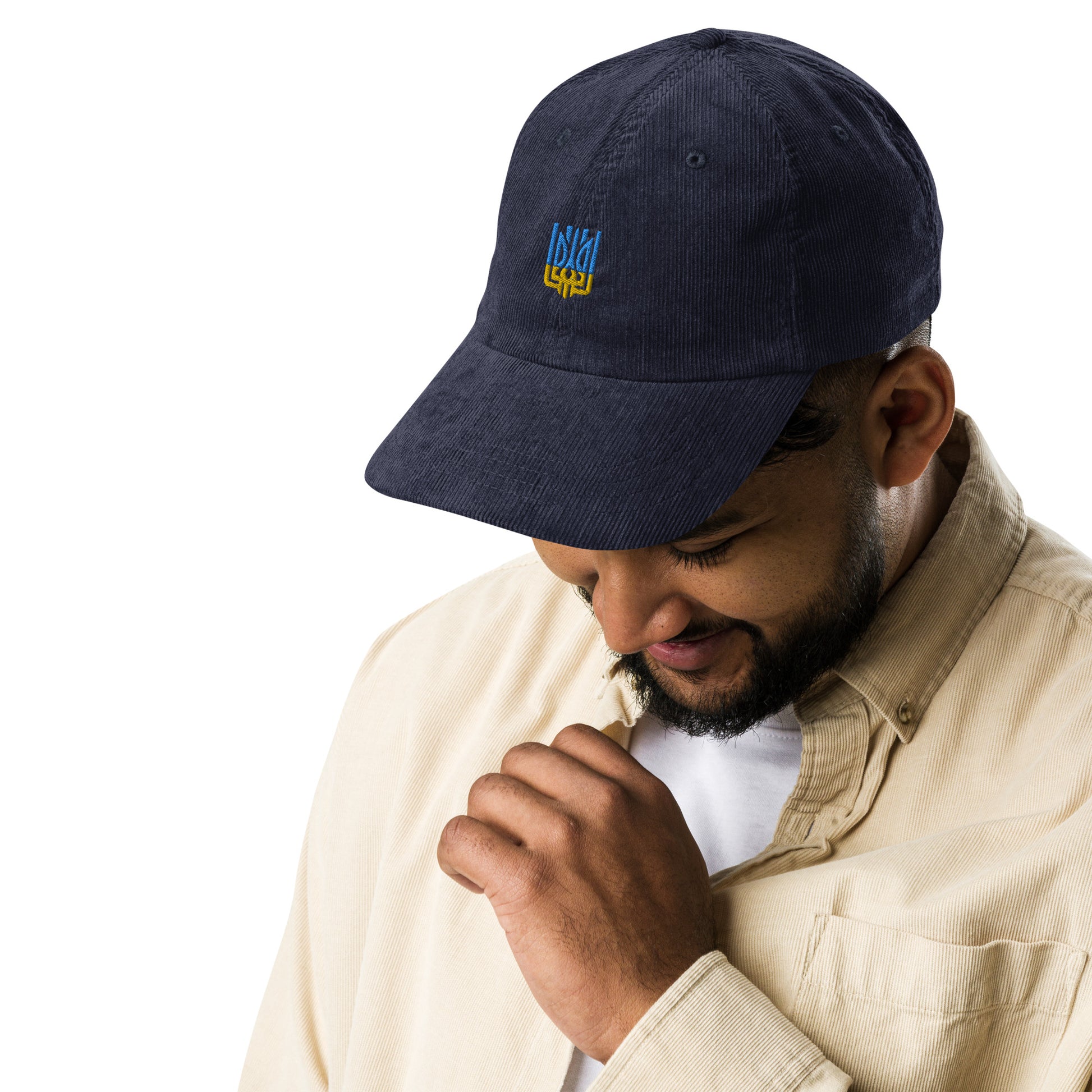 Vintage corduroy cap with Ukrainian Tryzub emblem worn by man, showcasing retro style and patriotic flair.