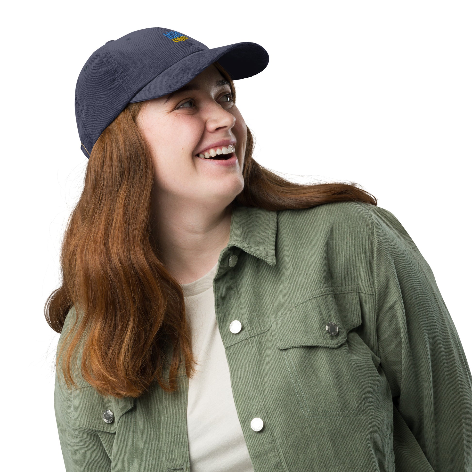 Person wearing a vintage corduroy cap with Ukrainian Tryzub, smiling in a green jacket.