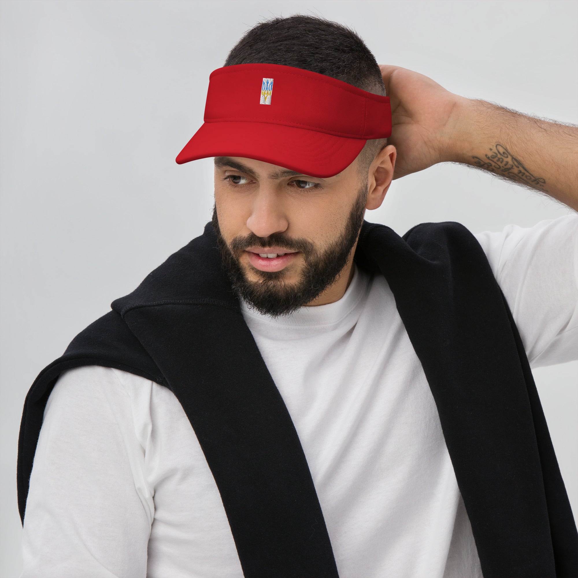 Red visor with Ukrainian Tryzub emblem worn by a man, showcasing adjustable design and stylish summer look.