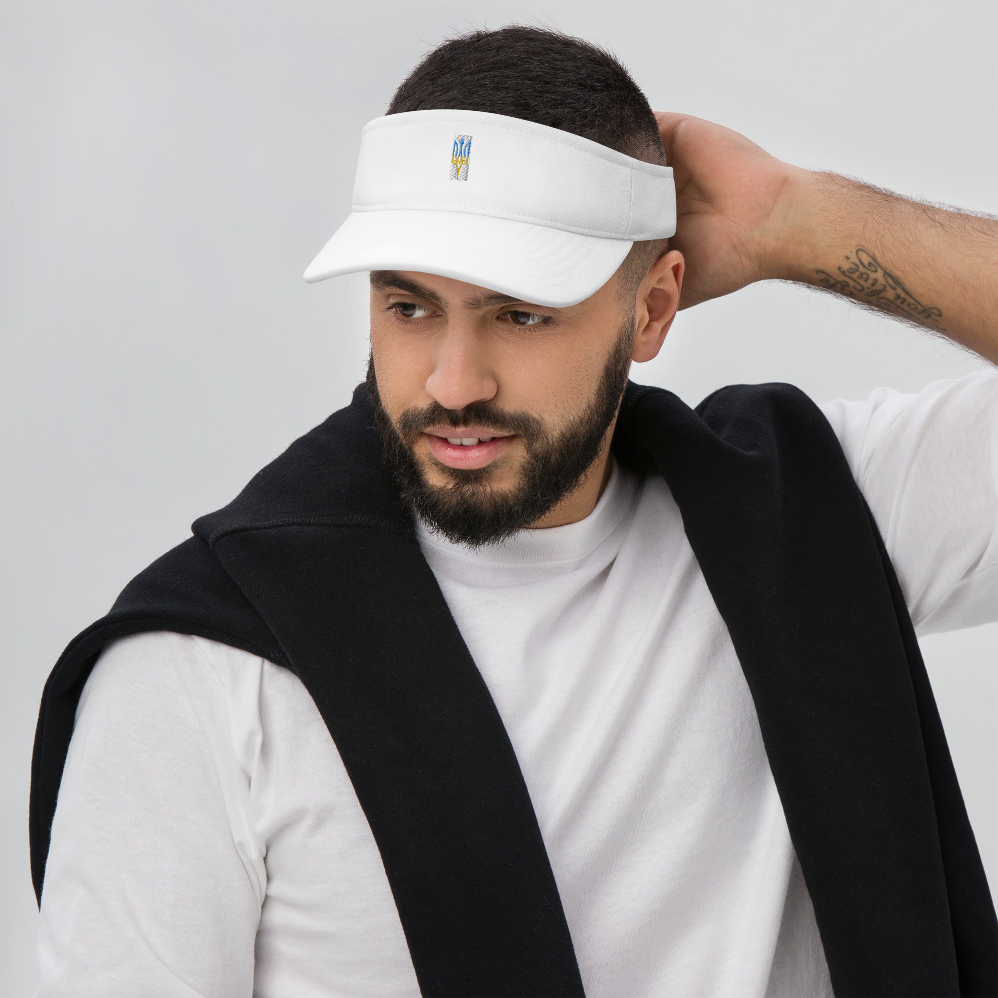 Man wearing a white visor with Ukrainian Tryzub emblem, showcasing summer style and heritage.